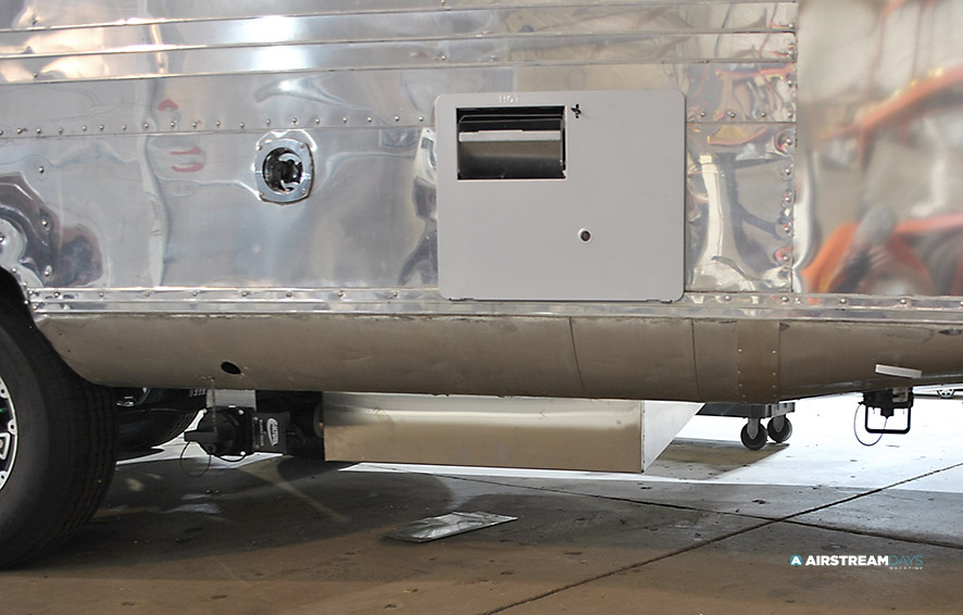 Gray water tank under 1959 Streamline trailer covered in aluminum