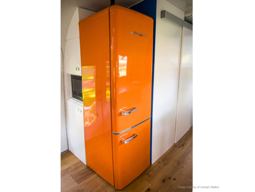 Orange 50's style fridge in 1963 Airstream Overlander