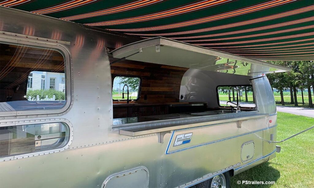 Camp Aramoni Airstream serving window in bar trailer